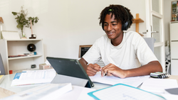 Image of a Man at a desk, studying on his laptop